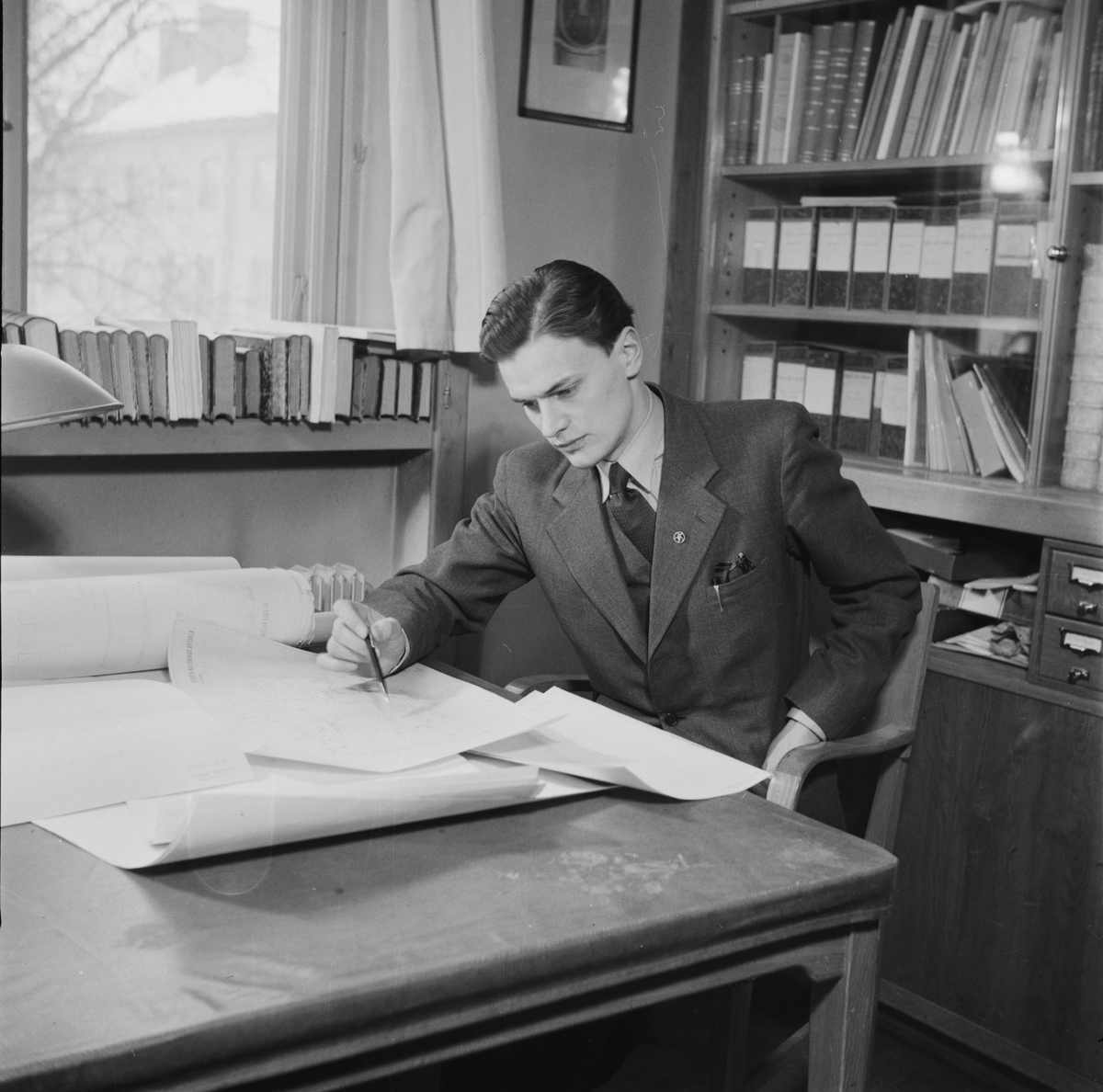 En man sittandes med ritningar, Östgöta nation inför restaurering, Uppsala 1946