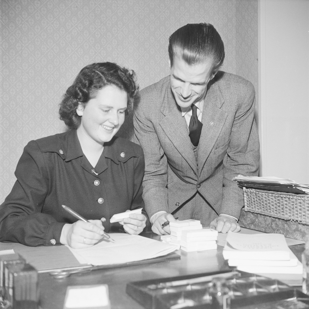 Man och kvinna vid skrivbord, inför Östgöta nations 300-årsjubileum, Uppsala 1946