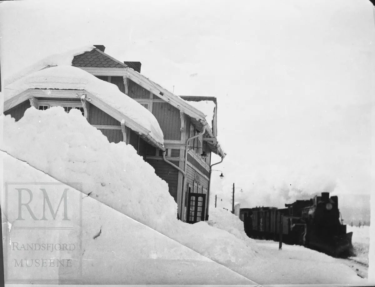 Vinterbilde fra Grua stasjon med tog på sporet.