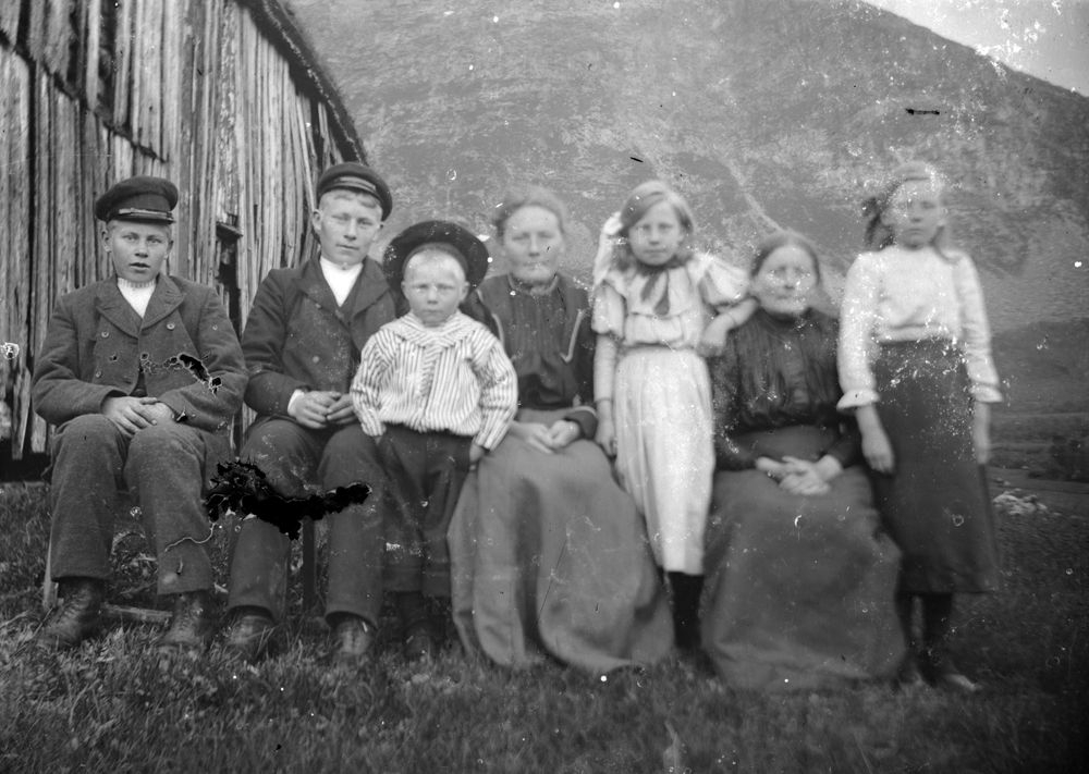 Leirfjord, Vatne, Yttergården. Personene er fosterfamilien som Marselius Jakobsen bodde bodde hos på Yttergården i Vatne, br.nr. 1. Nr. 2 fra høyre er Dorthea Johansdatter (1855-1943) som ble enke i 1900, hun var tante til Marselius. De andre personene er fem av hennes barn og ett barnebarn. F.v.: Nikolai Mathisen (f. 1893), Martin Mathisen, senere Vatne (f. 1890), Mathis Mørk Johannesen, tok navnet John Mathis Johnson i USA (f. okt. 1902) Marie Mathisen, mor til Mathis (f. 1883), Kristine Mathisen (f. 1899) Dorthea Johansdatter (f. 1855) og Jensine Mathisen (f. 1896). Fotografen Marselius Jakobsen var nevø av Dorthea og bodde hos henne i 1900. Dortheas nest eldste datter utvandret til USA i mai 1906.
Bildet er brukt Leirfjordkalenderen - juni 2021