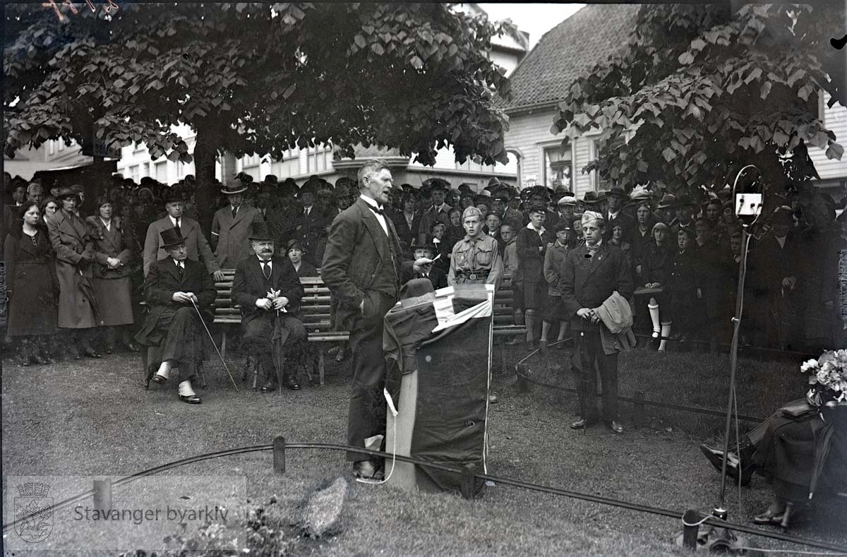 Mann holder tale. L.w. Hansen og Bertram C. Middelthon sittende til venstre på forrerste benk.