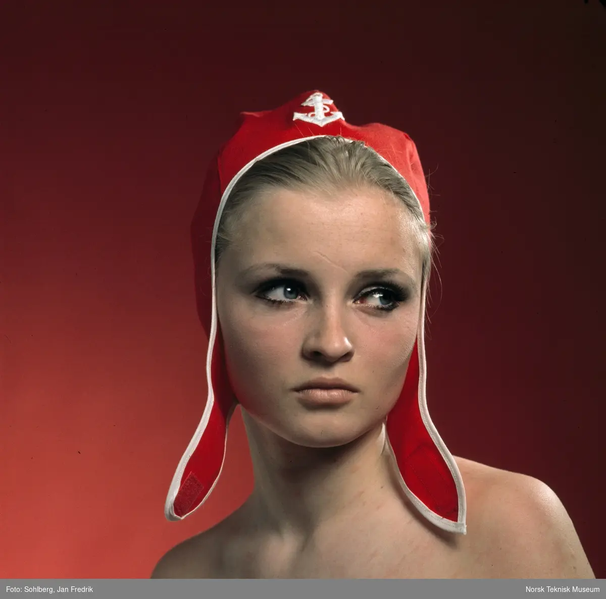 En kvinnelig modell viser fram tidens luemote. Lua er rød med hvitt anker, tettsittende med lange klaffer.