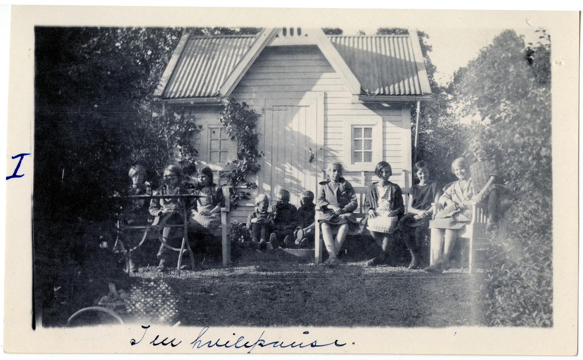 Skoleelevene fra Skøyen skole tar en hvilepause foran redskapshuset i skolehagen på Hengsengen, Bygdø Kongsgård ca. 1920.
