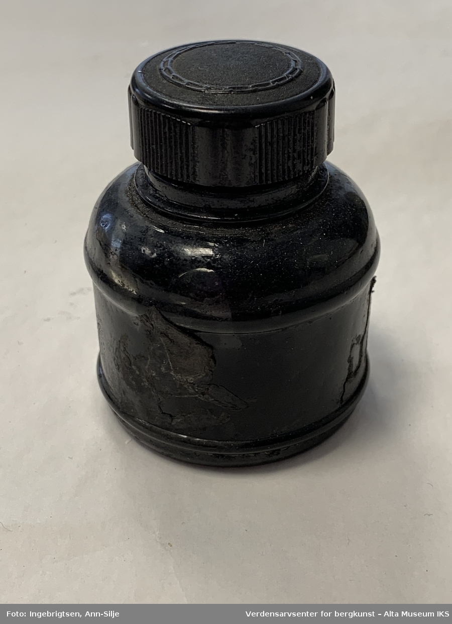 Form: Rund flaske med svart skrukork i plast.