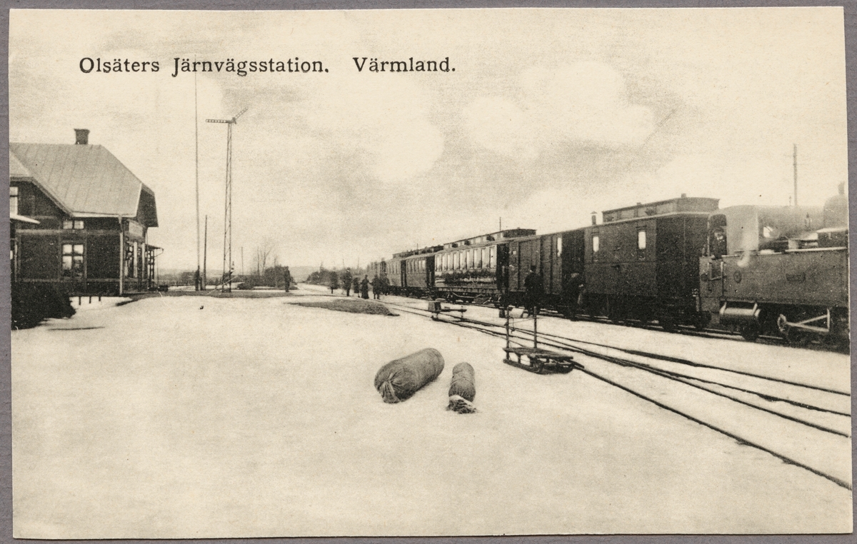 Stationsområde och tåg med vagnar under vintertid.
