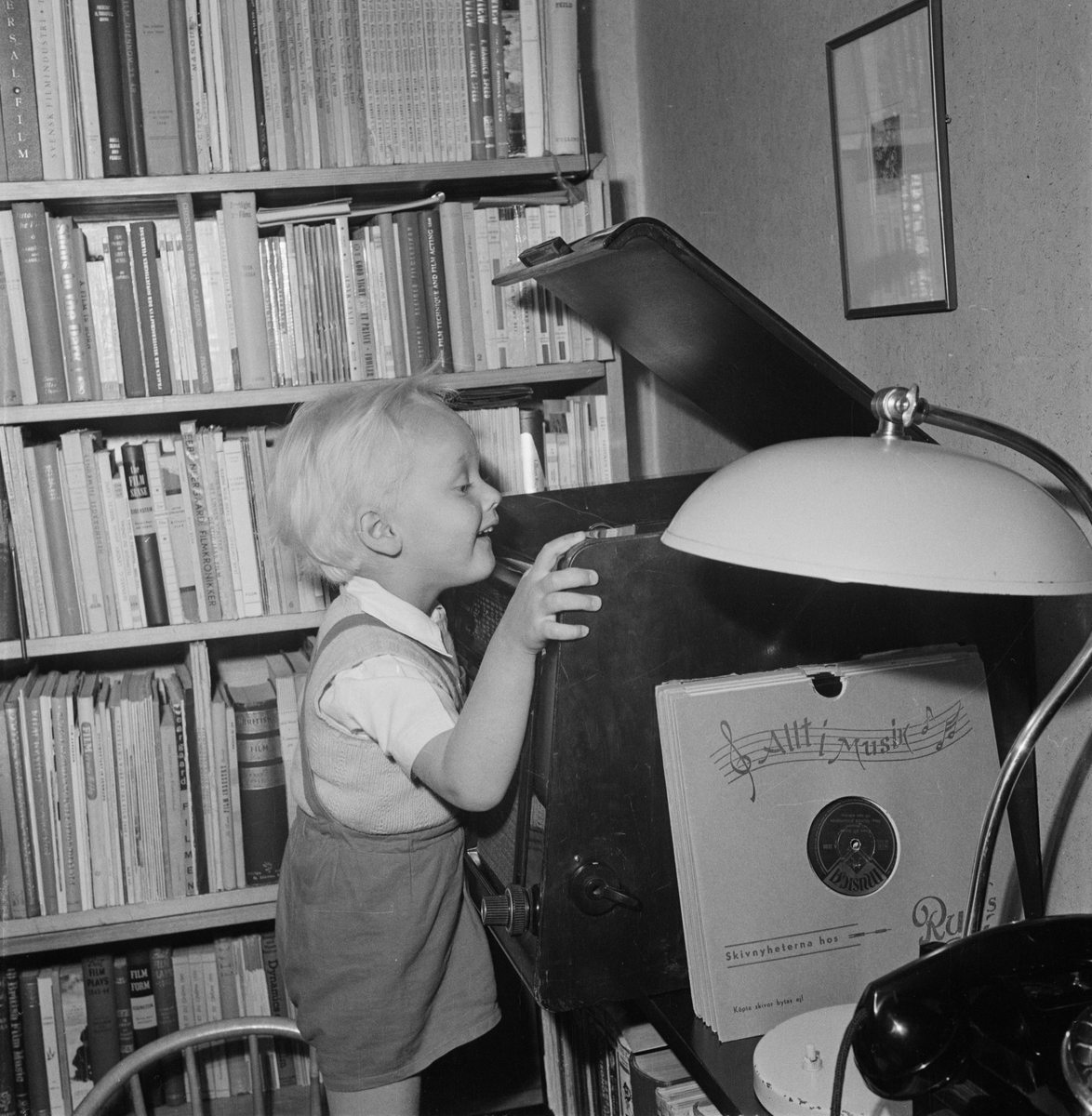 Pojke står vid grammofonspelare, Uppsala 1954