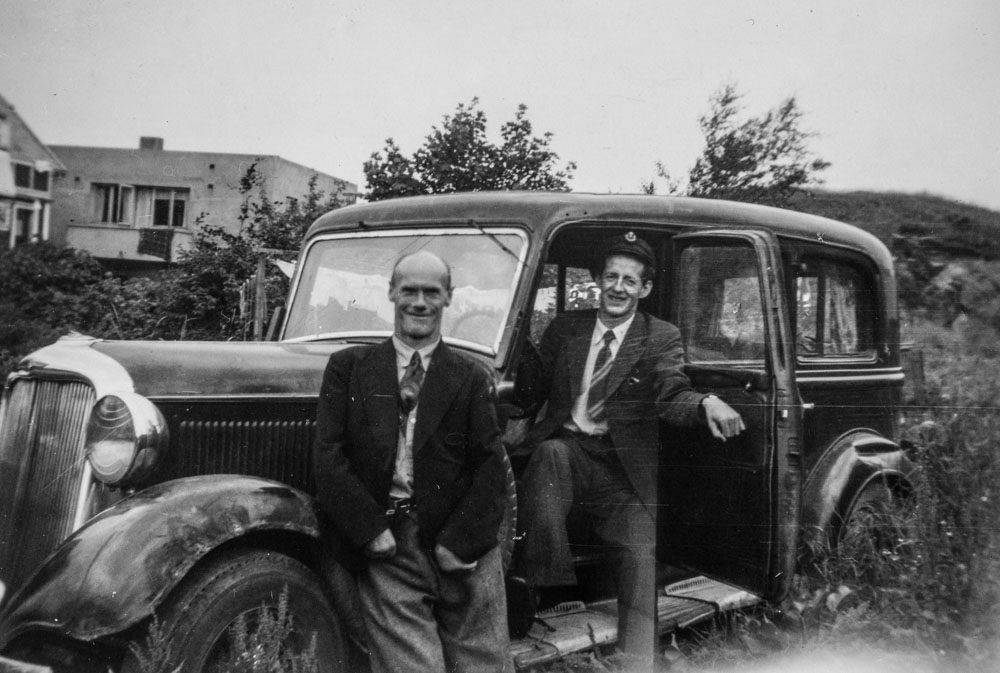 Leirfjord. F.v.: Aksel Ryssing stående ved bil. I døra står som sjåfør står Harald Langfors. Bilen var designet for drosjeformål, en Dodge 1933-35 modell montert ved Strømmens verksted. Det spesielle var 7-seter, norsk karosseri og høyt bak. (Kalt Strømmen-Dodge).
