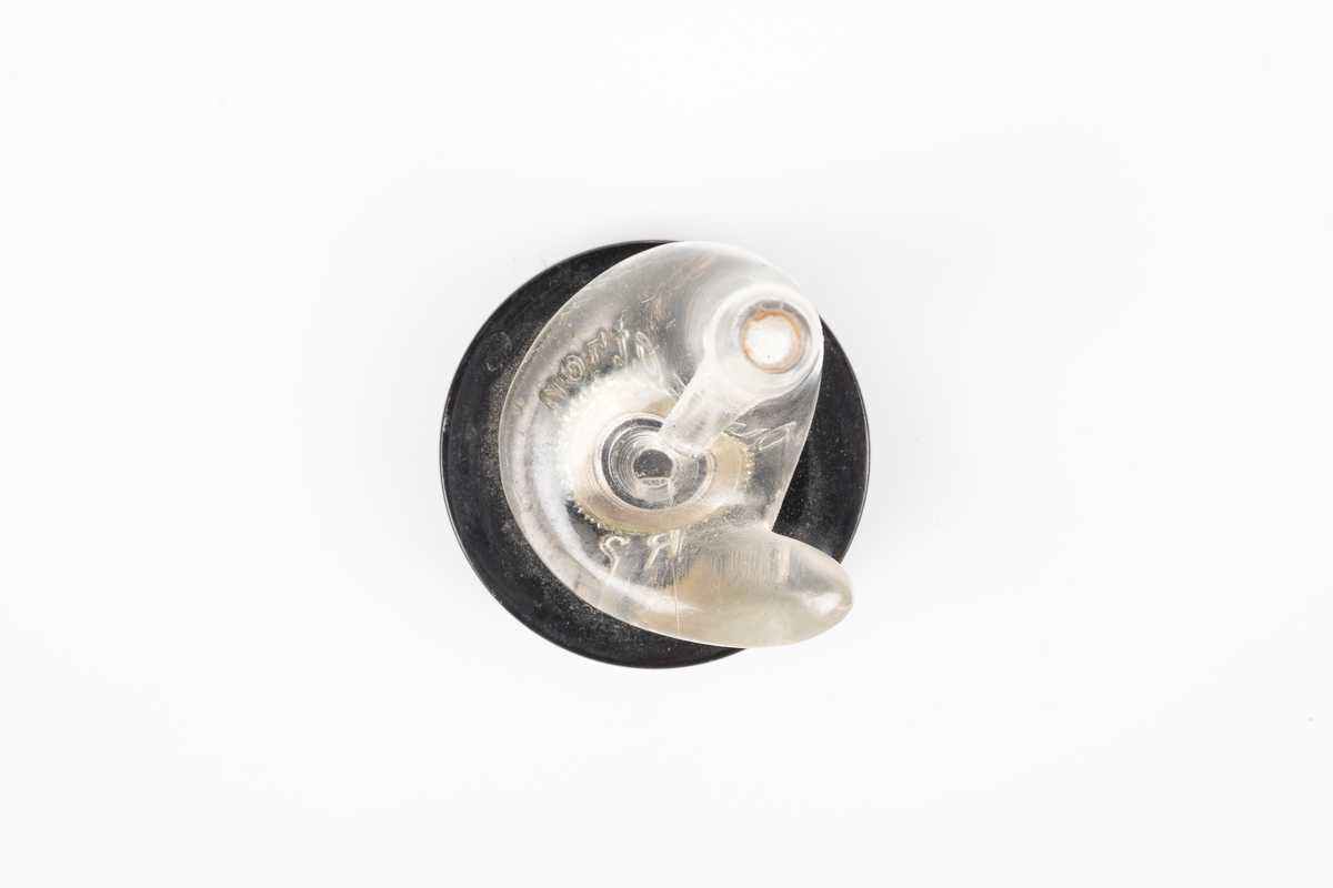 En av to ørepropper som kobles til en ledning. Den er i svart og gjennomsiktig plast.