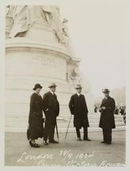 Tre menn og en kvinne står foran Dronning Victorias minnesme