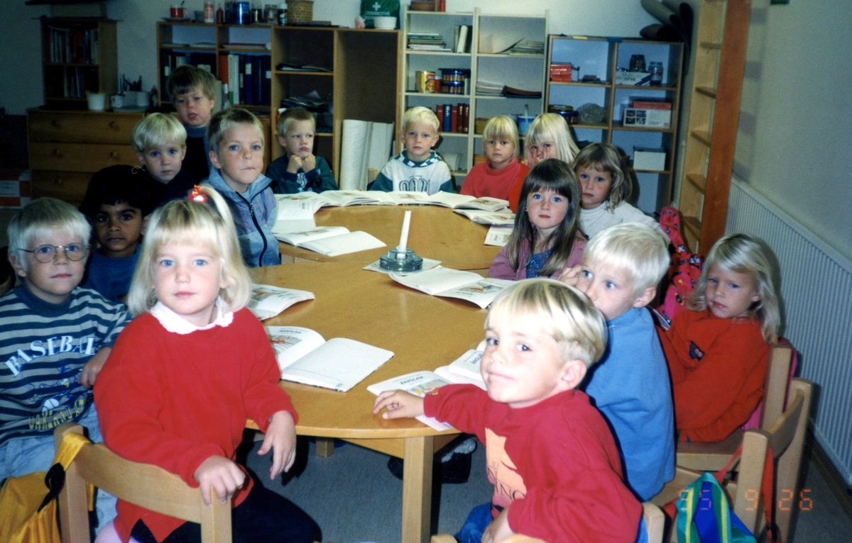 Barn sitter samlade runt ett bord i Kållereds församlingshem (Våmmedalsvägen 16), 1990-tal. Kyrkans barnverksamhet. Namnuppgifter saknas.