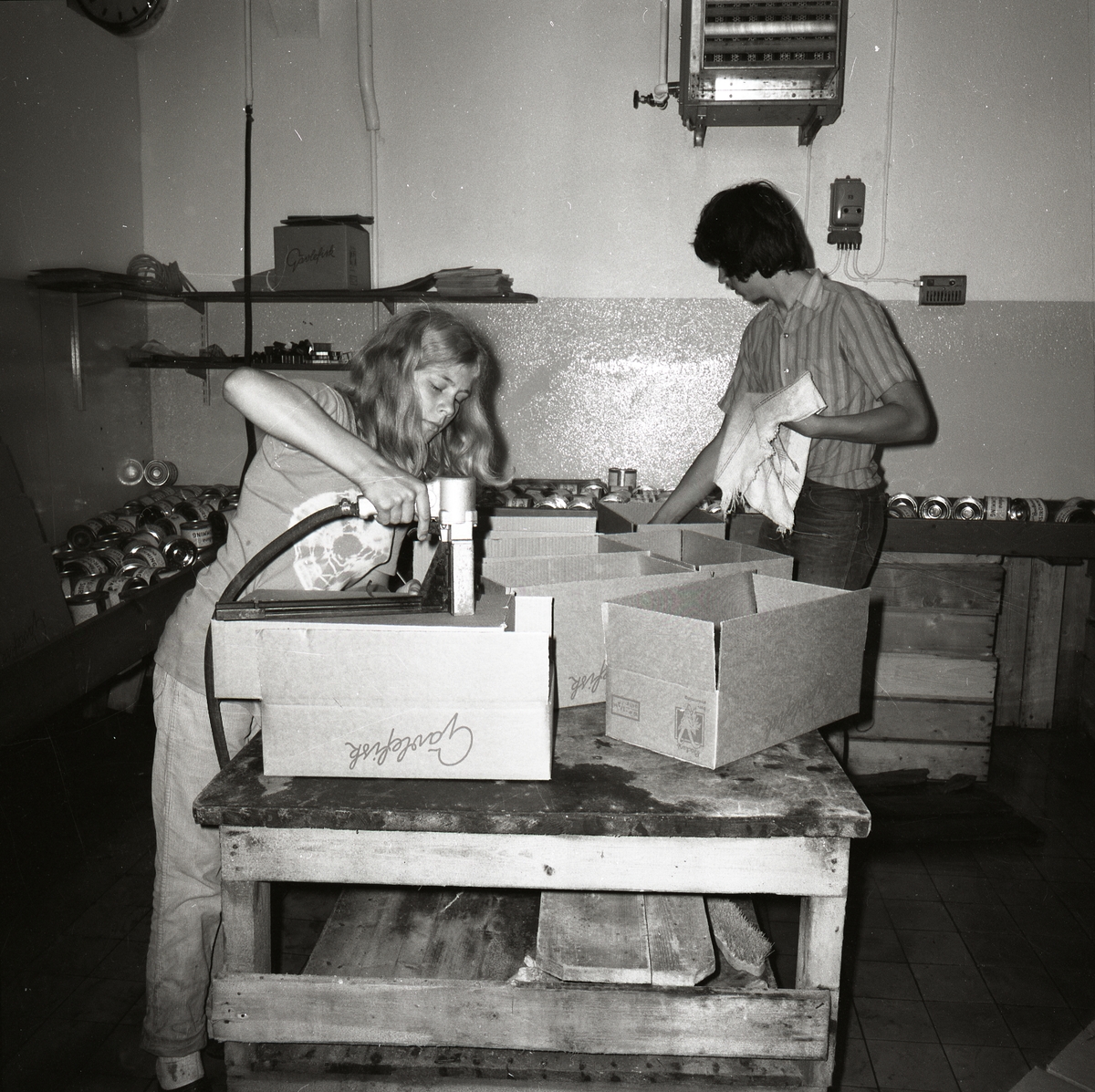 Två personer packar kartonger med surströmming vid Gävlefisk.