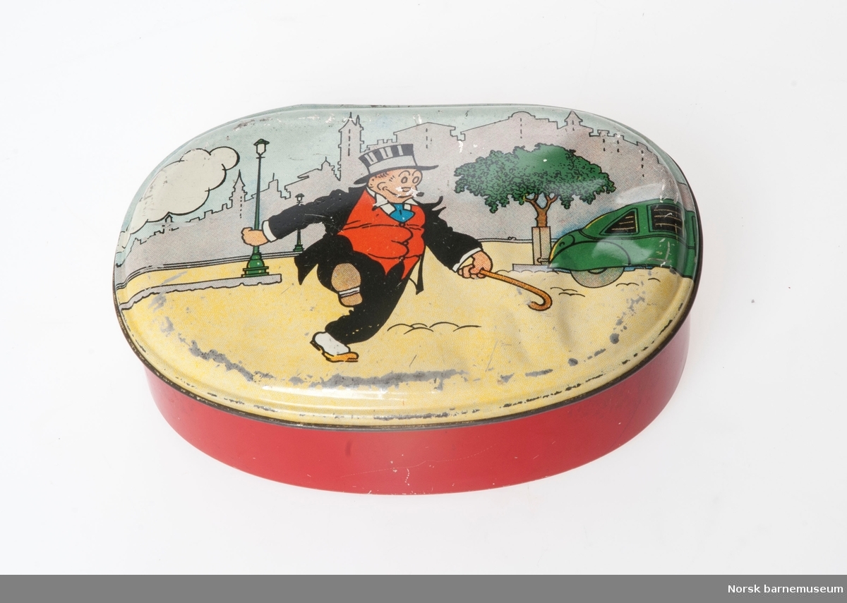 Matboks i metall. Rød med bilde av tegneseriefiguren Finnbeck som krysser en vei med stokk.  