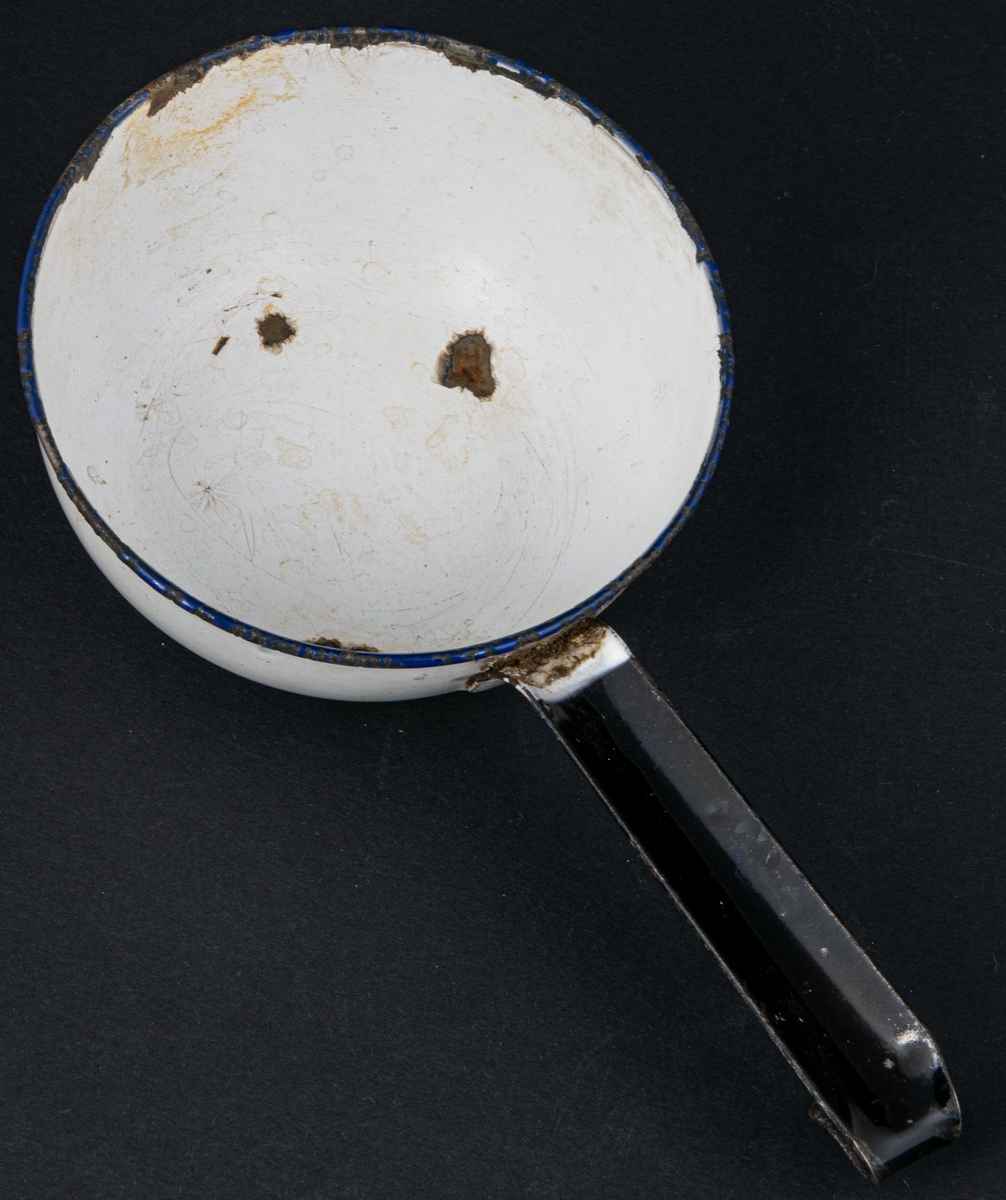 Acc.kat.
Skopa av emaljerad plåt, vit med blå mynningskant.
12 cm. märkt K.E.R Sweden