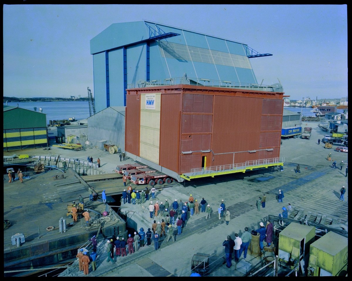 En stor modul til Statfjord A fraktes mot en lekter på Haugesund Mekaniske Verksted. Flere har kommet for å se på, og i bakgrunnen står Nordsjøhallen.