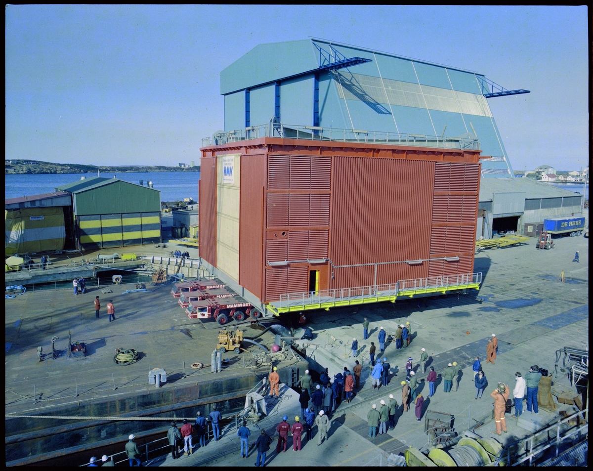 En stor modul til Statfjord A fraktes mot en lekter på Haugesund Mekaniske Verksted. Flere har kommet for å se på, og i bakgrunnen står Nordsjøhallen.
