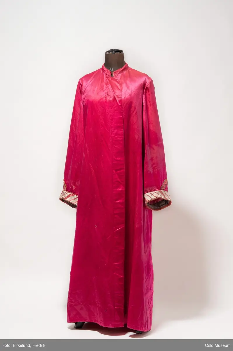 Cyklamenrød kjortel i silke. Mansjetter i rød og hvitstripet silke.