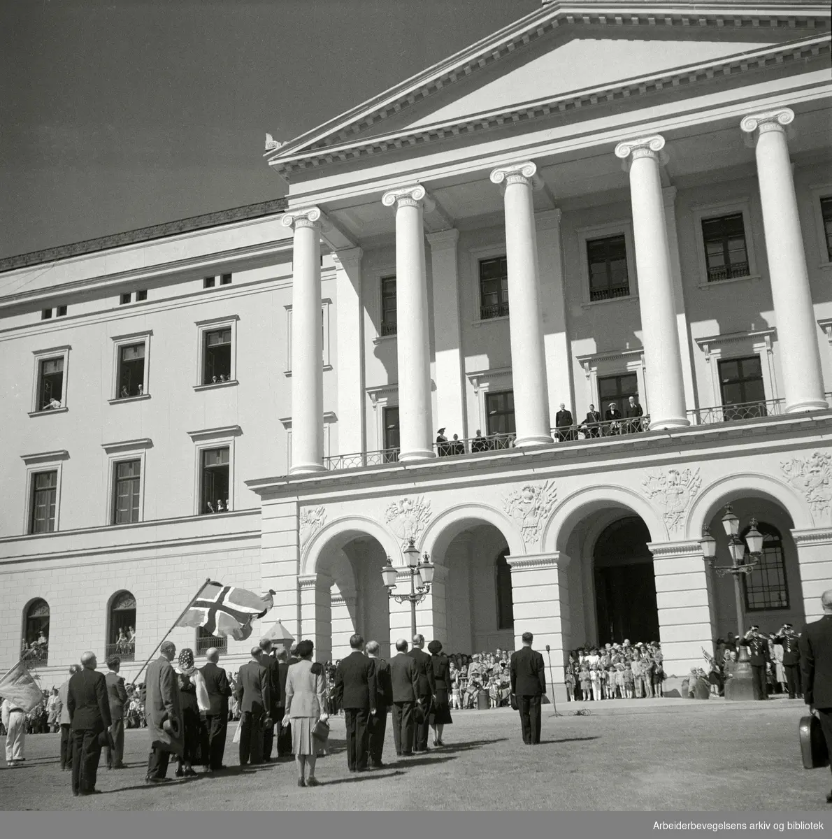 Flagghilsen foran Slottet og kongefamilien. 17. mai 1951. 17. Mai-komitéen. Kong Haakon VII. Kronprins Olav. Prins Harald.