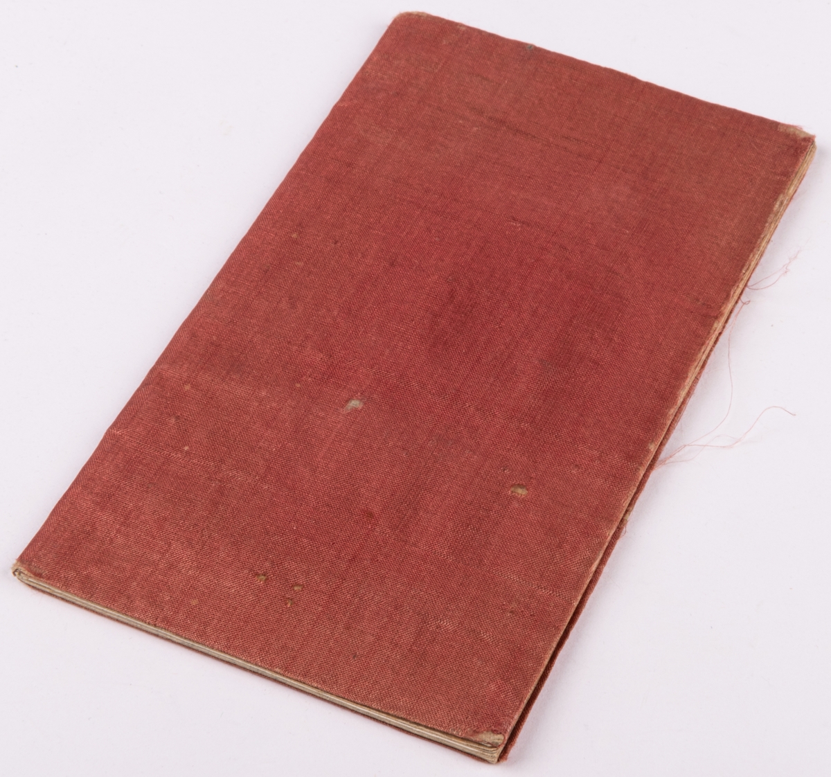 Anteckningsbok klädd med rött siden.
Inuti skrivet

"Från Clara Nordblad julafton 1848".