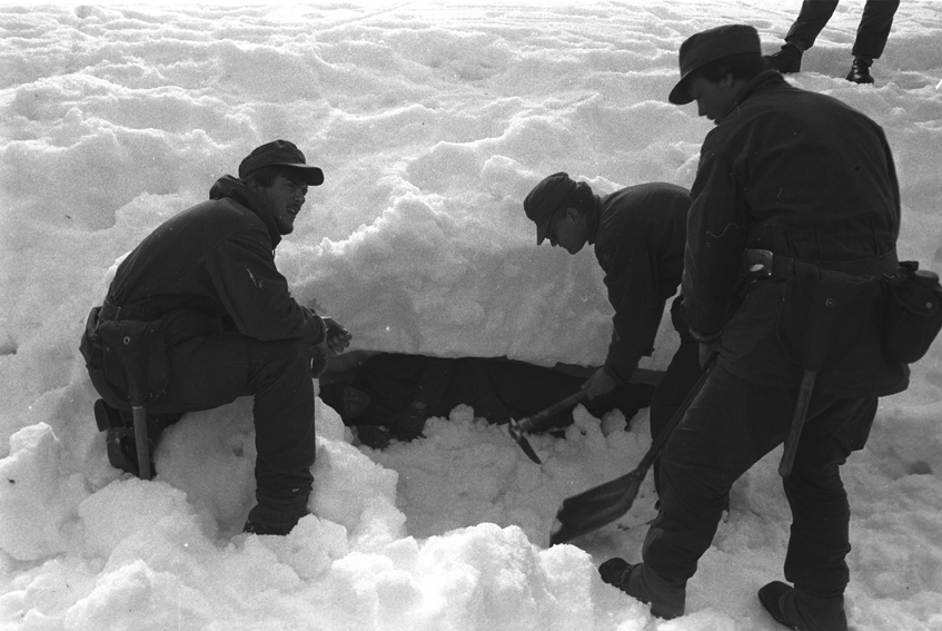 Tre befalsskoleelever graver frem en markør fra en snøskavel.