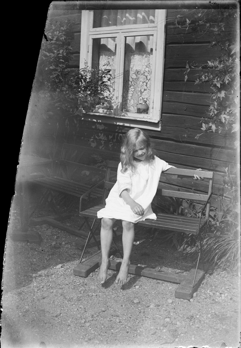 Tyra Edhlund sitter på en bänk, Östhammar, Uppland