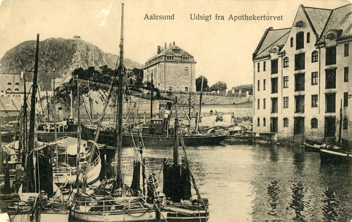 Oversiktsbilde sett fra Apotekertorget ved Brusundet i Ålesund med utsikt utover havneområdet og Rønneberghaugen. Flere seilbåter og en dampbåt ligger i sundet.