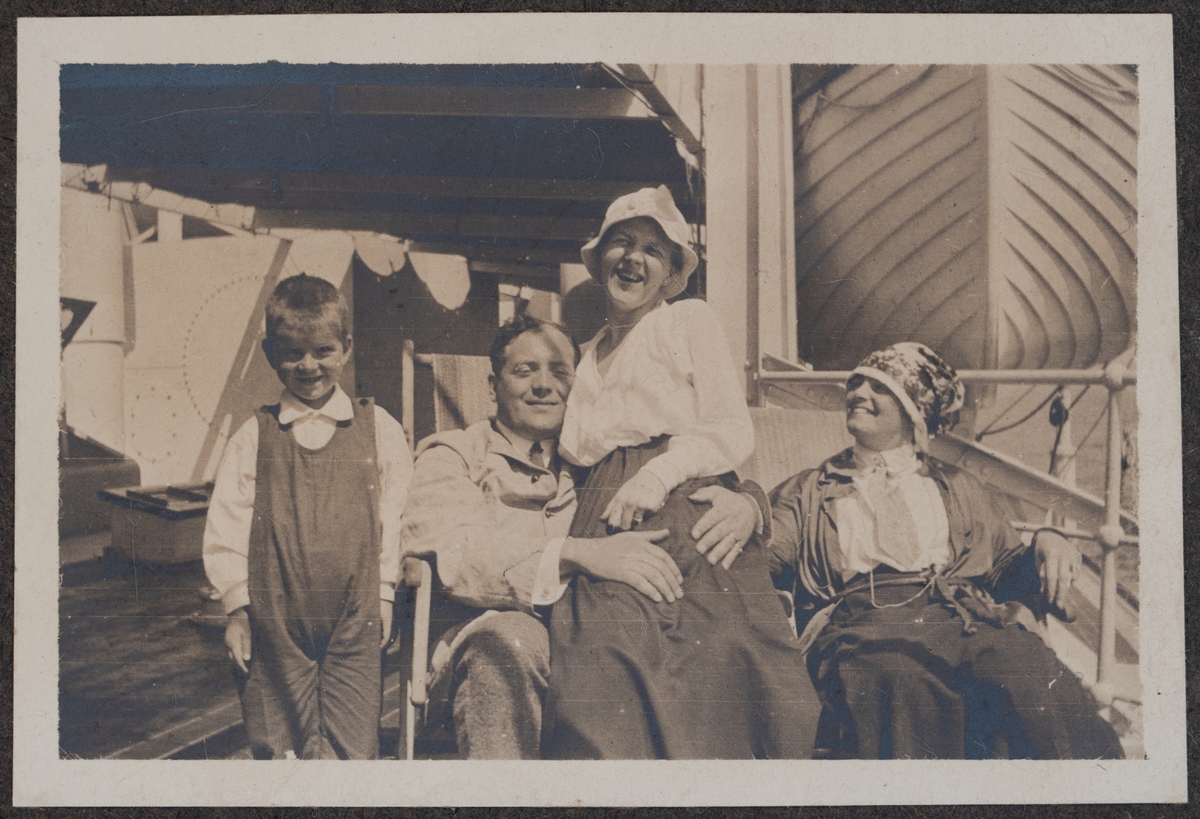 En pojke, en man samt två kvinnor på soldäck.
Bildtext: "En som tar efter behag."