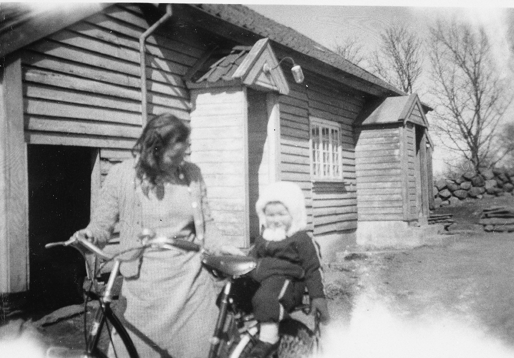 Olaug Time med sykkel og Solveig Undheim Oma på bagasjebrettet framfor det gamle heima huset på Time.