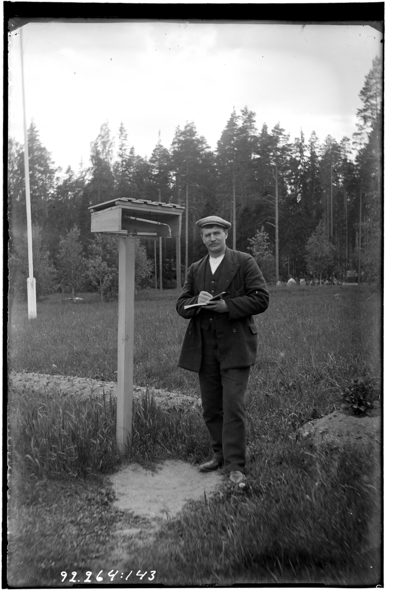 Hålahult sanatorium, exteriör, en man läser av temperatiren vid en väderstation.