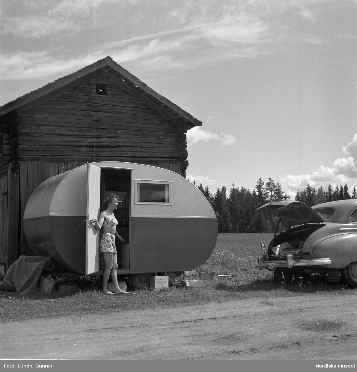 Motiv: (ingen anteckning) ;
Porträtt av en man författaren Frans G Bengtsson, en gärsgård, två kvinnor och två män ligger på marken och spelar schack vid en parkerad bil med husvagn, en kvinna står vid dörren till en husvagn, porträtt av en flicka som håller blommor.