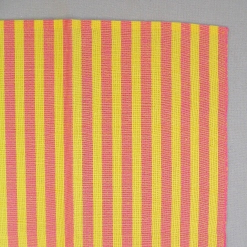 Långrandig handduk vävd i tuskaft med centimeterbreda ränder i varpriktningen. Varpen består av tvåtrådigt bomullsgarn i starkt gult och rosa. Inslaget består av gult entrådigt lingarn. Det är en smal tråcklad fåll i kortsidorna.Handduken är formgiven av Ann-Mari Nilsson och tillverkad av Länshemslöjden Skaraborg.