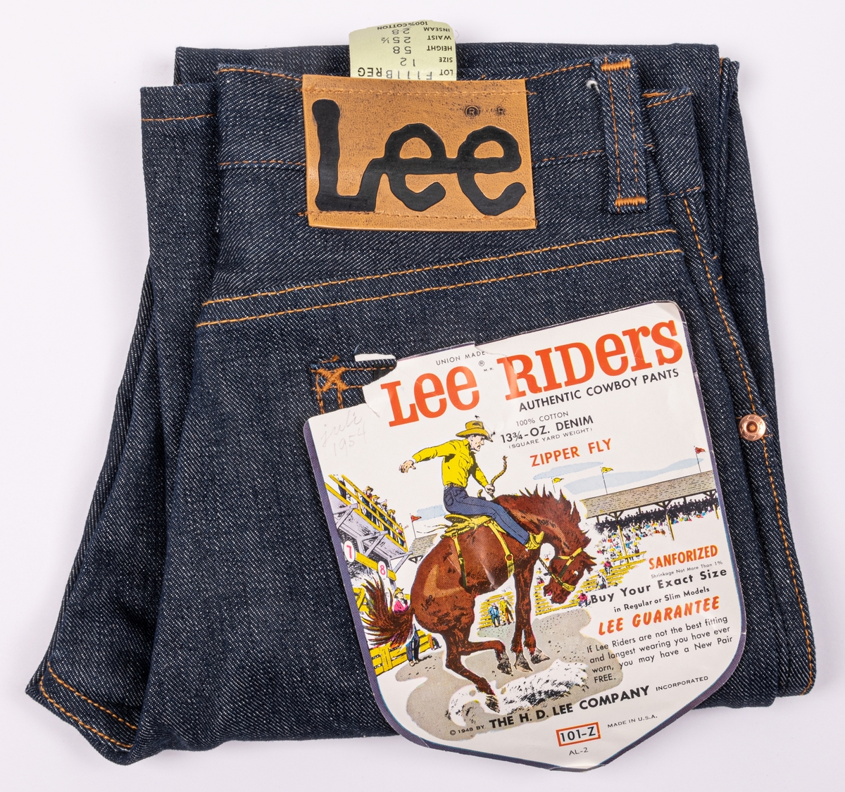 Ett par blå jeans med fällsömmar i benen. Gul-orange tråd. Metallknapp i midjan. Gylf med dragkedja, nitade fickor. Baktill märkt "Lee" på bit av konstläder. Dessutom en pappersetikett på bakfickan med texten: Lee Riders. Barnstorlek. "Authentic cowboy pants".