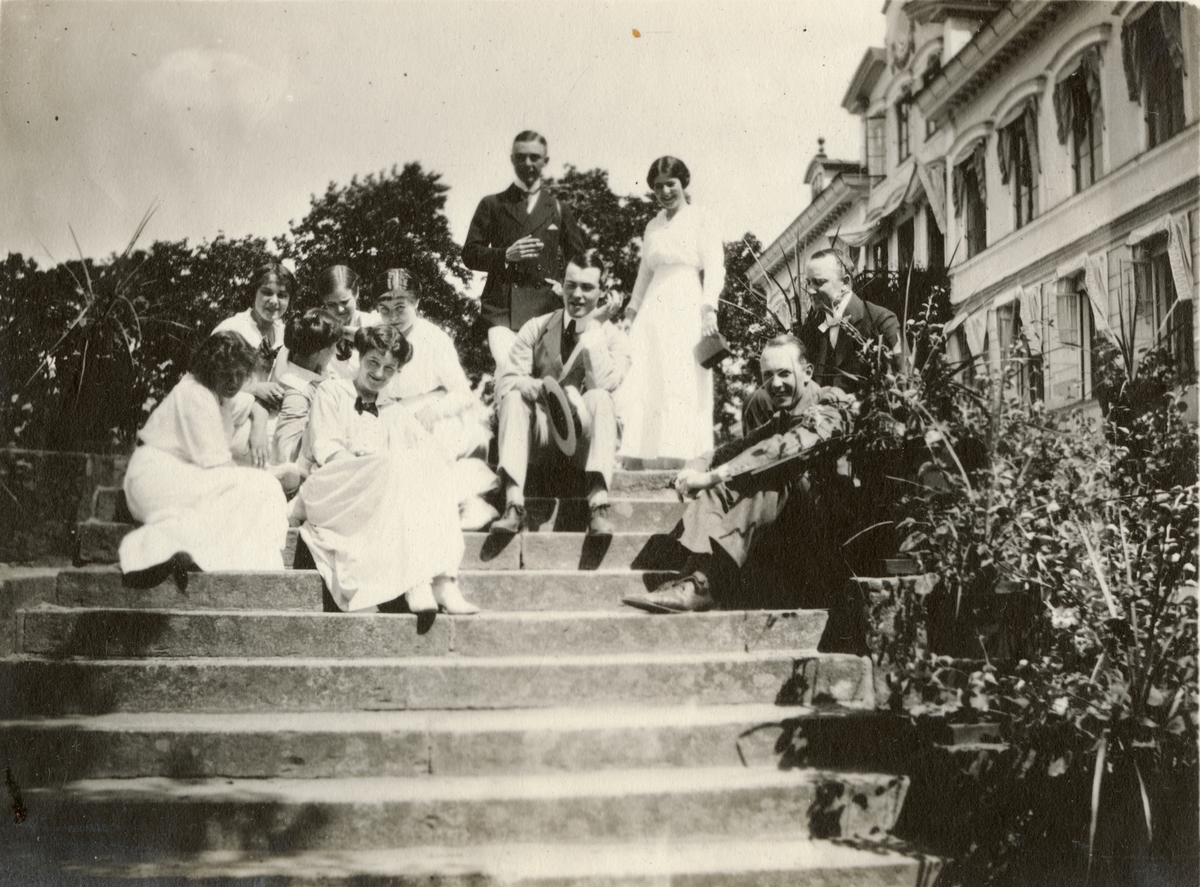 Män och kvinnor sitter i trapp, troligen vid prins Carls villa Parkudden på Djurgården i Stockholm.