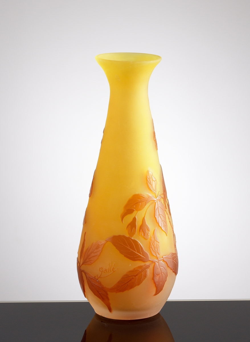 Halvopak, gul vas med etsat överfång i brunt. Växtmotiv med blommor och blad.