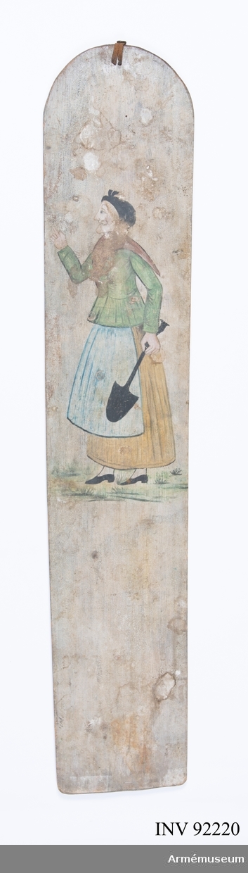 Träskylt bemålad på båda sidor. På ena sidan en soldat i uniform m/1845 för Andra Livgrendadjärregementet. Han bär troligtvis käppi samt livrem m/1864. På andra sidan en kvinna klädd i grön jacka, gul kjol och blått förkläde. På huvudet har hon svart klut och över axlarna en brun sjal. I handen håller hon en spade.