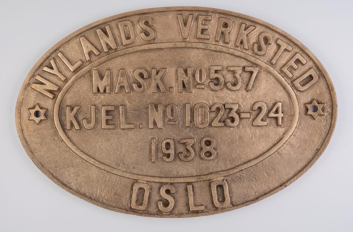 Plakett fra Nylands Verksted med kjelenummeret og maskinnummeret til D/S Octavian. Det er støpt følgende tekst inn i plaketten: Nylands verksted. Oslo. Mask.no.537. Kjel.No.1023-24. 1938.