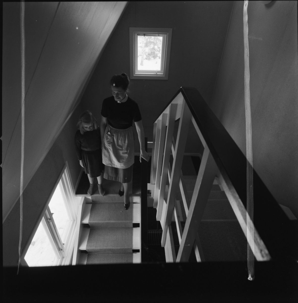 villa Ahlgren
Interiör, kvinna som går med litet barn uppför trappa.