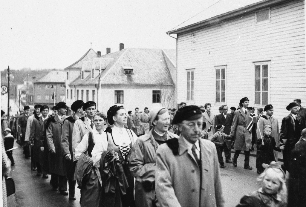 Lærarar ved Bryne Gymnas saman med koner og barn i 17. mai tog i 1957. Bedehuset "Saron" til høgre.