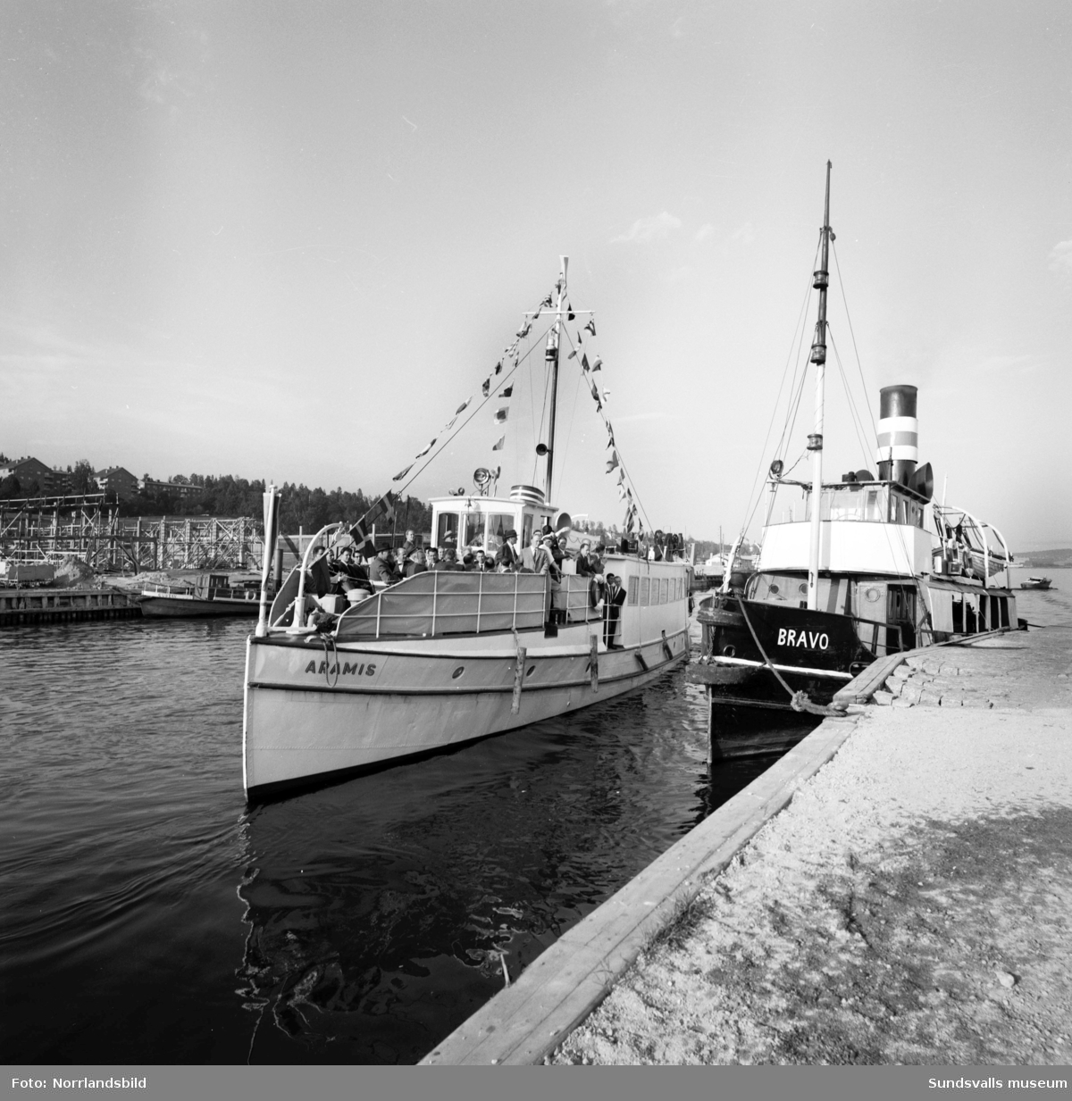 Båten Aramis avgår från Finnkajen. På Norra kajen syns pågående bygge av indystrilokaler.