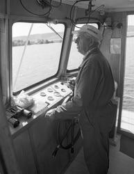 Skipper Arnt Svartedal, fotografert til rors i styrhuset på 