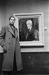 Tore Hamsun foran sitt portrett av faren Knut Hamsun.
