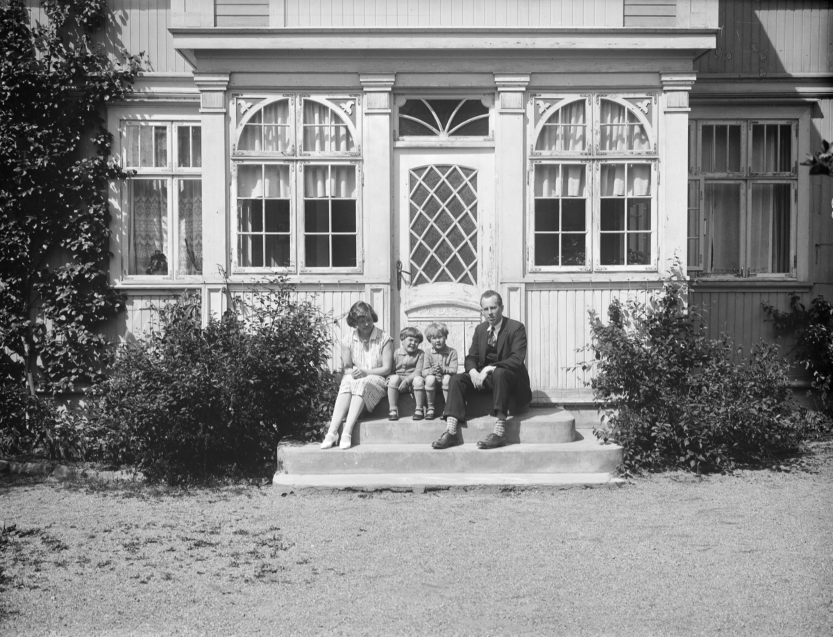 Skjønsberg med kone og to barn på trappen forran huset i Carl Lumholtzgate 6.
