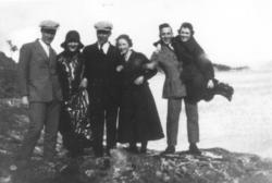 En munter ungdomsgjeng samlet ved sjøen. Tre kvinner og tre 