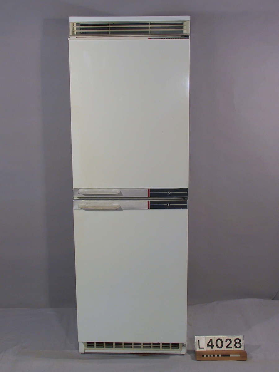 Kombinerat kyl- och svalskåp Elektro-Helios med två dörrar. Kylskået är vitlackerat med handtag och plastdetaljer i grått utförande. Logotypen är i svart, rött och silver. Ventilationsgallren är utförda i grå plast.