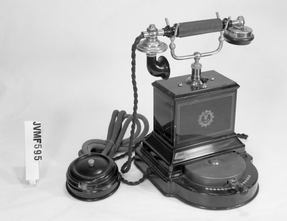 Bordstelefon, lokaltelefon, med självväljare för 15 linjer och galvanisk signalering. Av svart plåt.