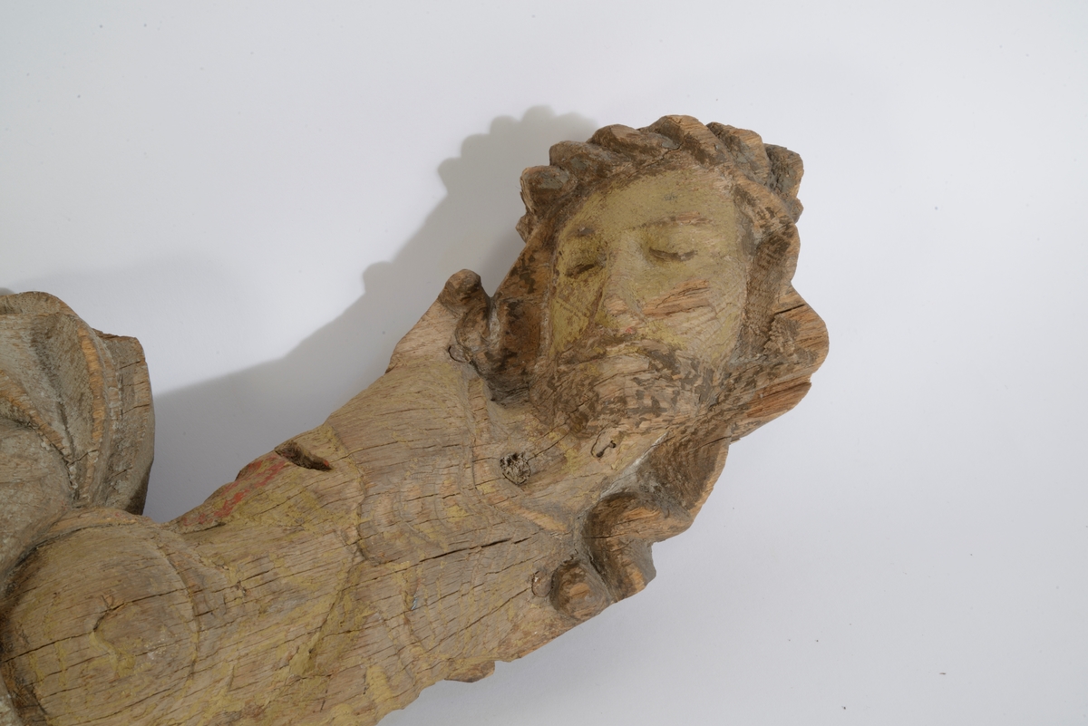 Kristus figur; fra krusifiks, kroppen svunget, hodet lagt over mot v., skjegget, lendeklede m. spor av hvit maling, rødm. fra lansestikket. Kryssede ben 