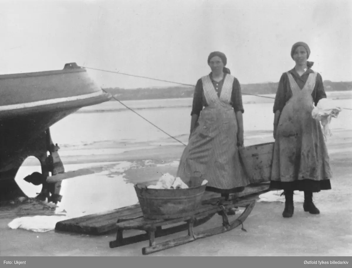 Klesvask i Øyeren, på isen ved Sleppetangen ca. 1920?
Fra venstre: Bolette Hovind f. 1885 fra Enebakk og Jenny Sandvik, f. Andresen. Båten til venstre er slepebåten "Mørkfoss".