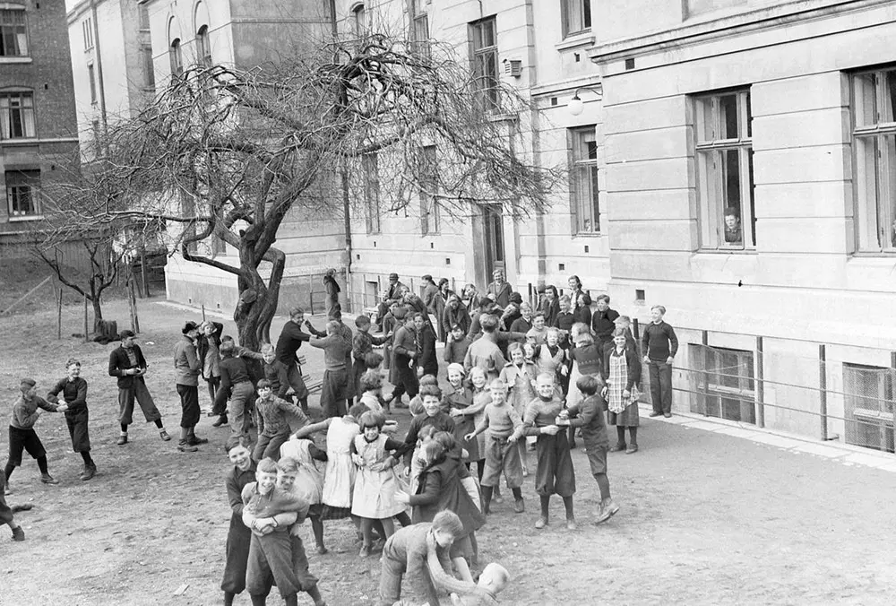 Svart-hvitt foto av ungdommer som leker i en bakgård.