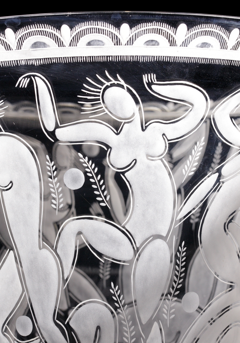 Design: Edward Hald. Stor skål på fat "Bollspelande flickor", med graverat motiv av just bollspelande flickor. Bilden har stark koppling till den stil som framför allt kopplas till Matisse, som Hald gick i lära hos under tiden han studerade konst i Paris.