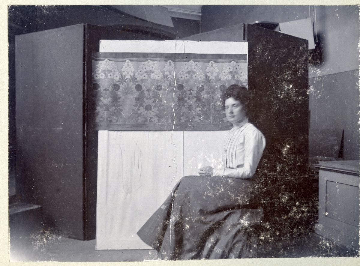 Stockholm. 
Kvinna sittande framför tavla. 1901.