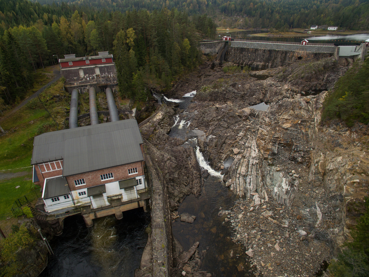 Dalsfos kraftstasjon med utløp, tre klinka stålrøyr og ein dam i betong.